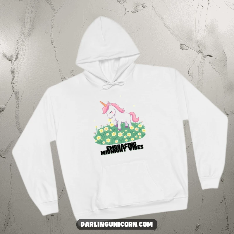 Funny unicorn gently nuzzling glowing moonflowers, depicted on a warm and comforting hoodie.