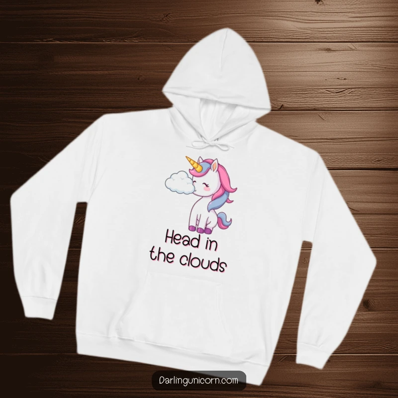 Funny unicorn hoodie depicting a unicorn playfully interacting with a soft cloud, creating a dreamy scene.