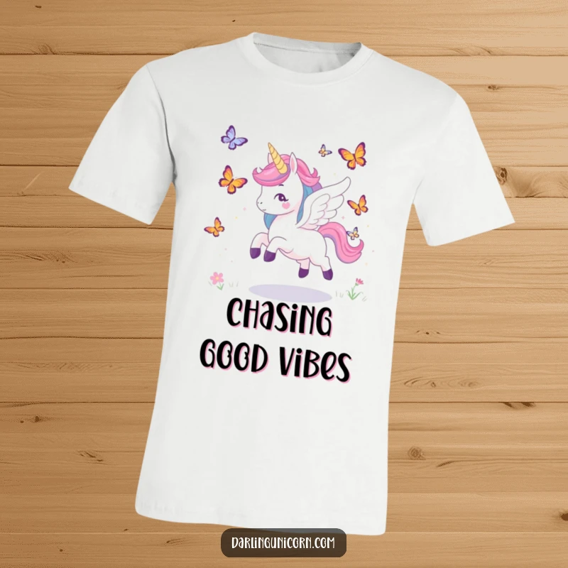 Funny t-shirt depicting a unicorn with majestic wings playfully pursuing fluttering butterflies, embodying freedom and joy.